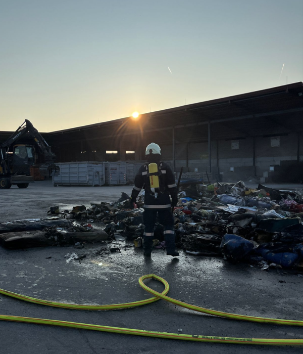 Brandreste und Feuerwehrmann mit Atemschutz