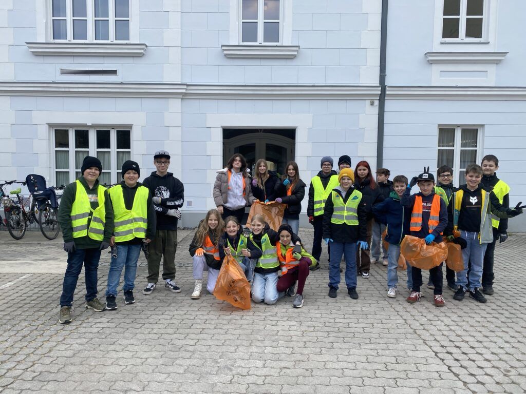 Gruppenbild von Schülerinnen und Schülern mit Warnwesten und Müllsäcken