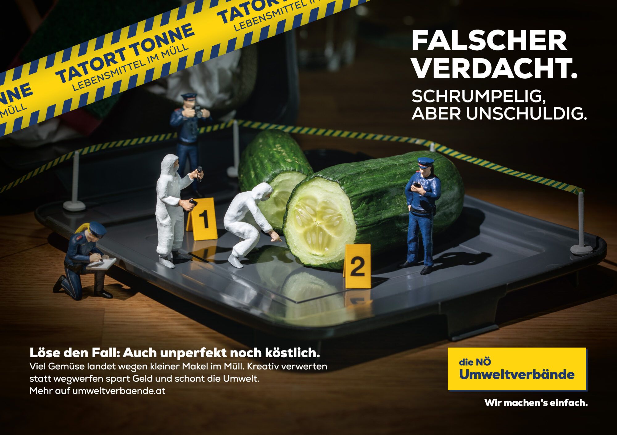 Miniaturpolizisten inspizieren den Tatort Tonne mit Gurken.