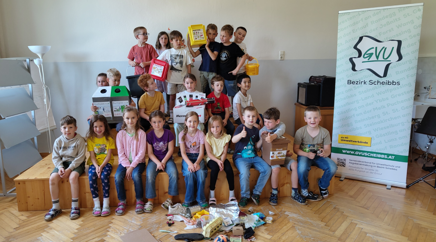 Sch&uuml;lerinnen und Sch&uuml;ler stehen mit Vorsammelhilfen auf einem kleinen Podest, wie bei einem Klassenfoto.