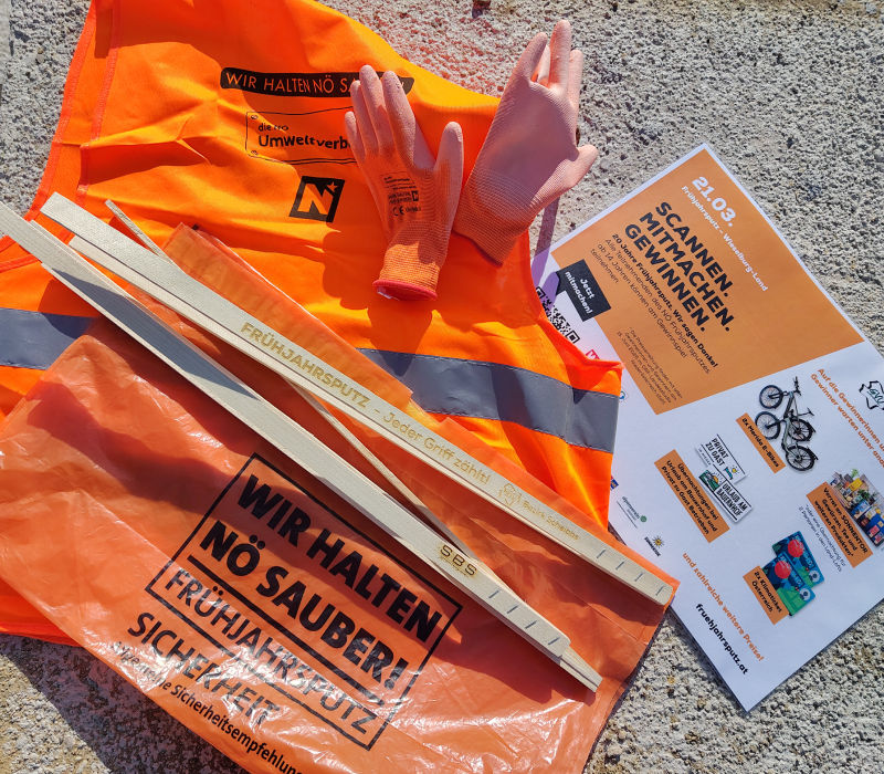 orangener M&uuml;llsack, Handschuhe, M&uuml;llgreifer aus Holz, zusammengefaltete Warnweste