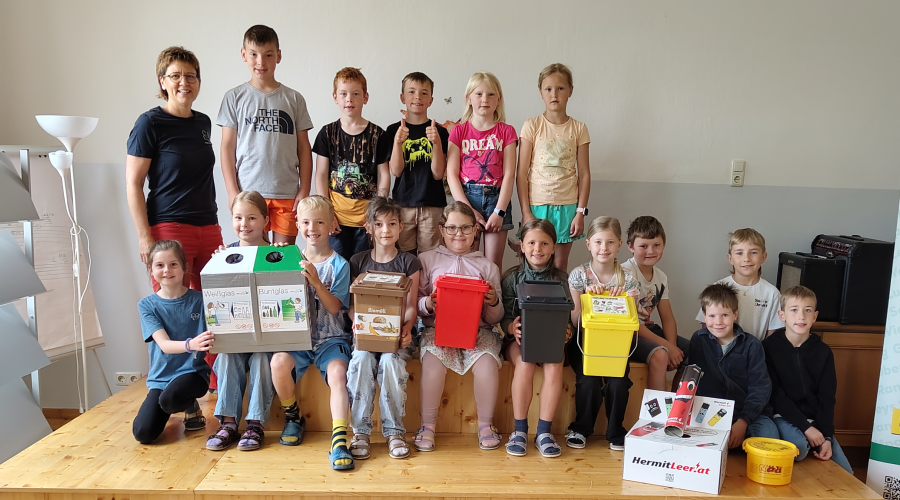 Sch&uuml;lerinnen und Sch&uuml;ler stehen mit Vorsammelhilfen auf einem kleinen Podest, wie bei einem Klassenfoto.