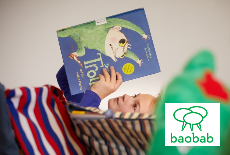 Kind liegend mit Buch in den Händen, Logo baobab