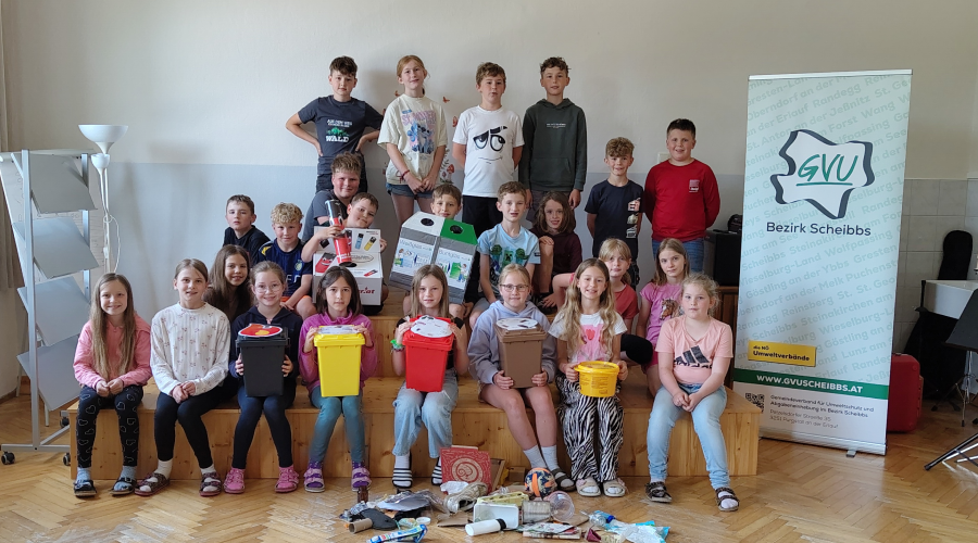 Sch&uuml;lerinnen und Sch&uuml;ler stehen mit Vorsammelhilfen auf einem kleinen Podest, wie bei einem Klassenfoto.